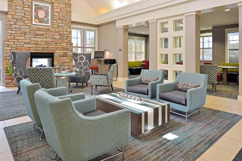 a lobby with chairs and tables and a fireplace at Residence Inn by Marriott Denver Airport at Gateway Park in Aurora