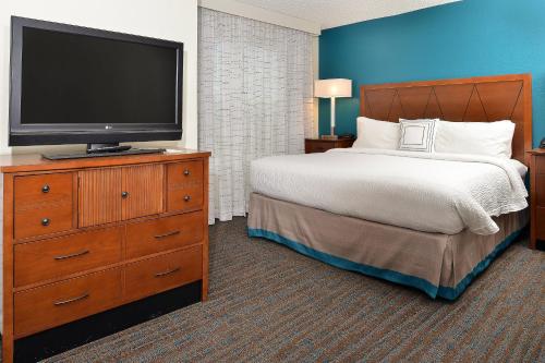 a bedroom with a bed and a flat screen tv at Residence Inn by Marriott Denver Airport at Gateway Park in Aurora