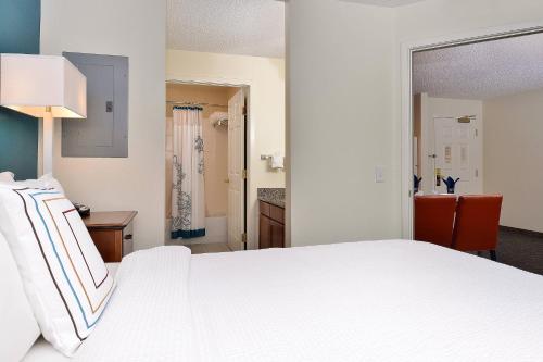 a bedroom with a white bed and a bathroom at Residence Inn by Marriott Denver Airport at Gateway Park in Aurora