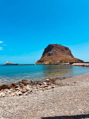a island in the ocean with a cruise ship in the distance at Ritsos Family Apartment in Monemvasia