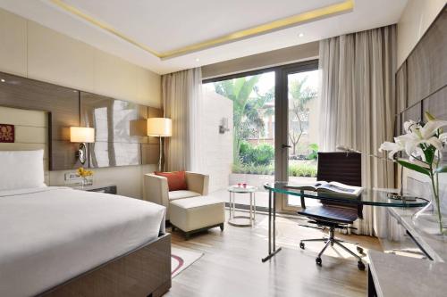 una camera d'albergo con letto e scrivania di JW Marriott Mumbai Sahar Airport a Mumbai