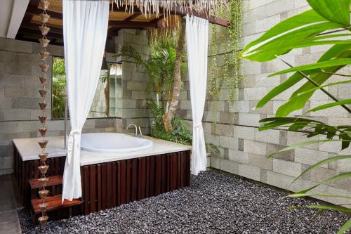 a bathroom with a bath tub and a shower at Fairfield by Marriott Bali Legian in Legian
