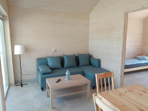 a living room with a blue couch and a table at Zante Sarbinowo in Sarbinowo