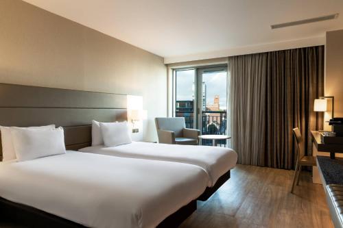 ein Hotelzimmer mit einem großen Bett und einem großen Fenster in der Unterkunft AC Hotel by Marriott Birmingham in Birmingham