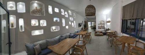a restaurant with tables and couches and a wall with mirrors at Hotel Flisvos in Megalochori