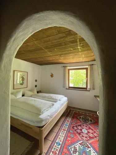 Schlafzimmer mit einem Bett, einem Fenster und einem Teppich in der Unterkunft Ferienwohnung Zita Weber in Neustift im Stubaital