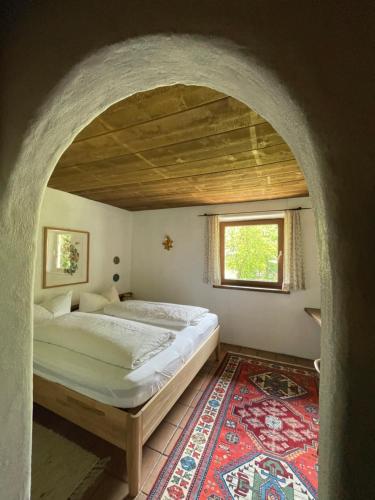 a bedroom with a bed and a window and a rug at Ferienwohnung Zita Weber in Neustift im Stubaital