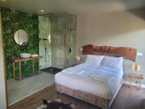 ein Schlafzimmer mit einem großen Bett und einer Dusche in der Unterkunft INFINITY HOUSES in Ponte da Barca
