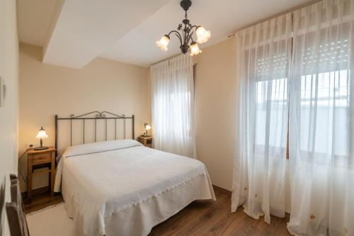 a bedroom with a bed and a large window at Pría, apartamento en Ribadesella in Ribadesella