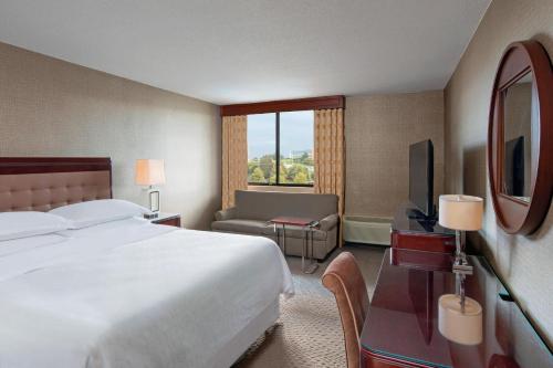 a hotel room with a bed and a television at Sheraton Harrisburg Hershey Hotel in Harrisburg