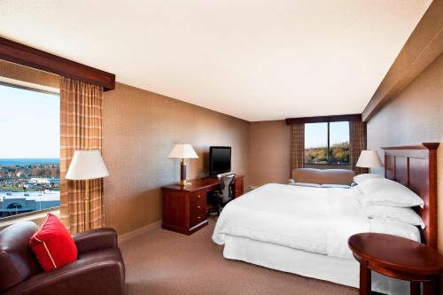 a hotel room with a bed and a large window at Sheraton Harrisburg Hershey Hotel in Harrisburg