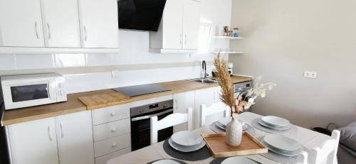 a white kitchen with a table and a microwave at Vistas mar y montaña LasNegras in Las Negras