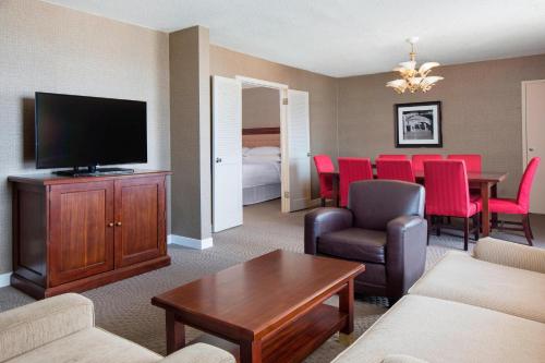 a living room with a couch and a television and a table at Sheraton Harrisburg Hershey Hotel in Harrisburg