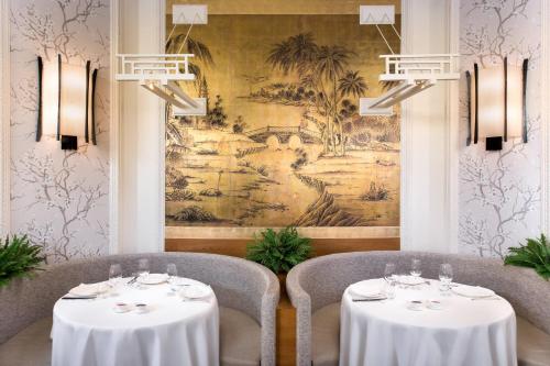 a dining room with two tables and a painting at Hotel Maria Cristina, a Luxury Collection Hotel, San Sebastian in Donostia-San Sebastián