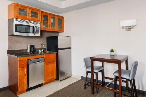 a kitchen with a refrigerator and a table with chairs at Residence Inn Atlanta Downtown in Atlanta