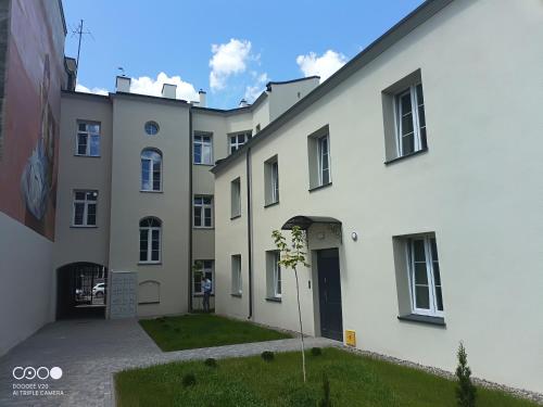 een groot wit gebouw met een binnenplaats bij Niedziałkowskiego Radom in Radom