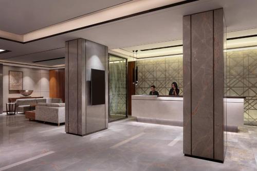 a lobby of a hotel with a person in a mirror at Courtyard by Marriott Amritsar in Amritsar