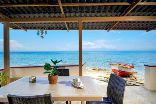 a table and chairs with a view of the ocean at To Kyma - Seafront House in Skala Kallirachis