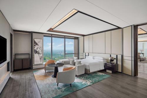 成都市にあるSheraton Chengdu Piduのベッドとテーブルと椅子のある寝室