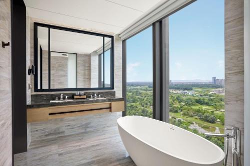 a bathroom with a tub and a large window at Sheraton Chengdu Pidu in Chengdu