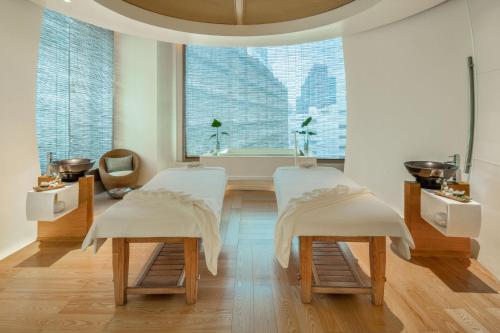 a room with two white chairs and a window at Le Meridien Bangkok in Bangkok