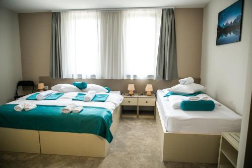 um quarto de hotel com duas camas com toalhas em Garni Hotel IMPERIUM Subotica em Subotica