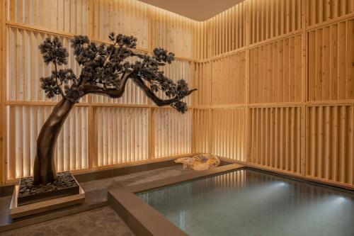 a room with a bonsai tree and a pool at Le Meridien Bangkok in Bangkok
