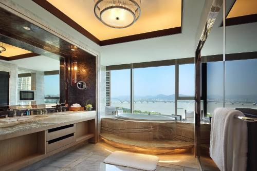 a bathroom with a tub and a large window at Sheraton Grand Hangzhou Binjiang Hotel in Hangzhou