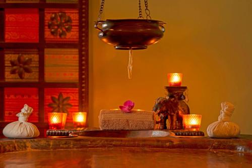 a table with candles and a chandelier and lights at Le Meridien Abu Dhabi Resort in Abu Dhabi