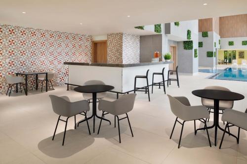 a lobby with tables and chairs and a pool at Element by Westin City Center Doha in Doha