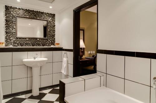 a bathroom with a sink and a mirror at Protea Hotel by Marriott Blantyre Ryalls in Blantyre