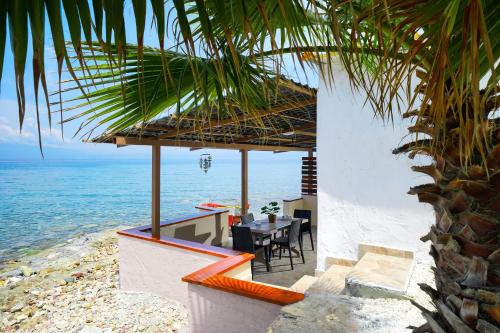 una casa en la playa con mesa y sillas en To Kyma - Seafront House, en Skala Kallirakhis