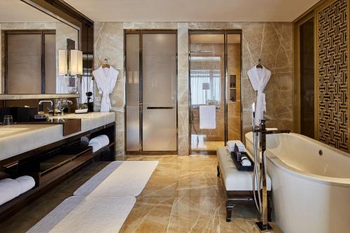 ein Badezimmer mit einer Badewanne und einem Waschbecken in der Unterkunft The Ritz-Carlton Hong Kong in Hongkong