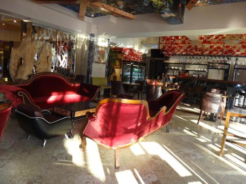 una habitación con 2 sillas rojas y un bar en Kingship Hotel Kaohsiung Inter Continental en Kaohsiung