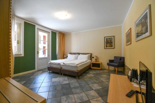 een slaapkamer met een bed en een stoel erin bij Aquazzurra Resort & Aparthotel in Cannobio