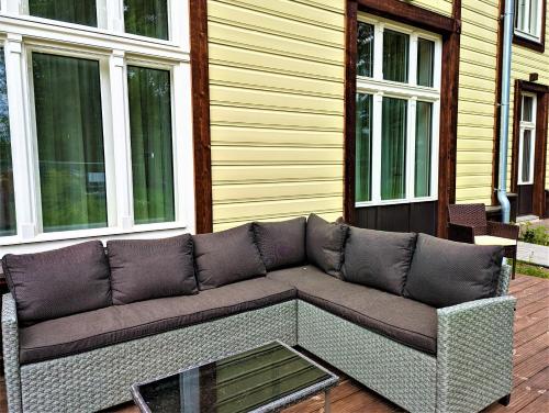 a couch sitting on a patio in front of a house at Emajõe Keeltekool Apartment in Tartu