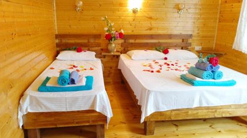 two beds in a wooden room with cakes on them at Abkhazsky Dvorik in Gagra