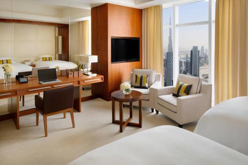 a hotel room with a bed and a desk with a computer at JW Marriott Marquis Hotel Dubai in Dubai