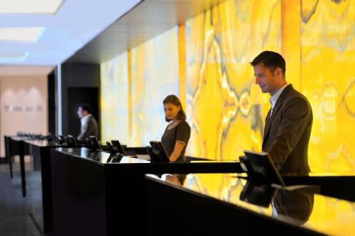 a man and a woman standing in front of a counter at JW Marriott Marquis Hotel Dubai in Dubai