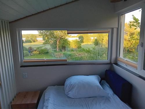 a small bedroom with a bed and a window at Chatka Święty Spokój in Piotrowice