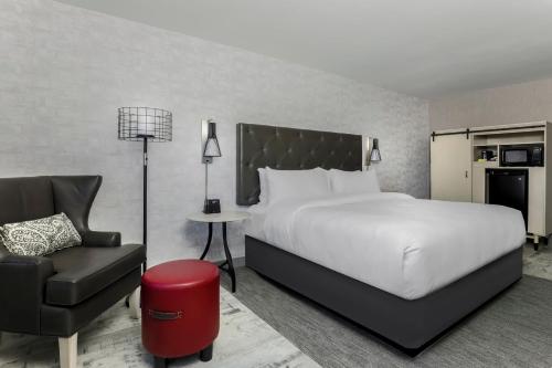 Habitación de hotel con cama y silla en Four Points by Sheraton Amarillo Central, en Amarillo