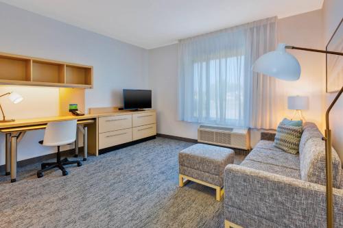 a living room with a couch and a desk with a computer at TownePlace Suites by Marriott Nashville Airport in Nashville