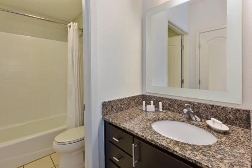 a bathroom with a sink and a toilet and a mirror at TownePlace Suites by Marriott Nashville Airport in Nashville