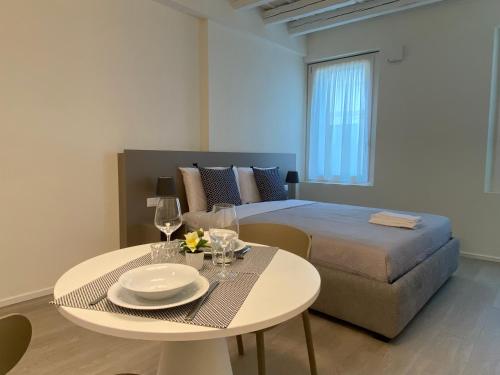 una camera con letto e tavolo con bicchieri da vino di Residenza SubitoSanto - Appartamento 1A Ruzzante a Padova
