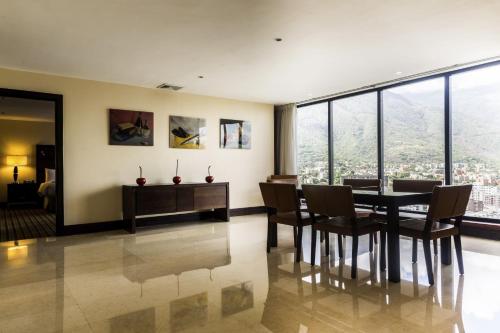 Renaissance Caracas La Castellana Hotel في كاراكاس: غرفة طعام مع طاولة وكراسي