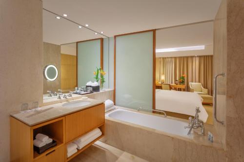 a bathroom with a tub and a bed in a room at ITC Sonar, a Luxury Collection Hotel, Kolkata in Kolkata