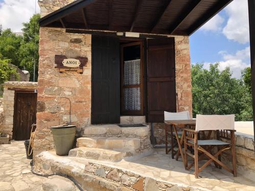 a stone house with a table and chairs outside at ANOI 1-bedroom country House in Episkopi Pafou