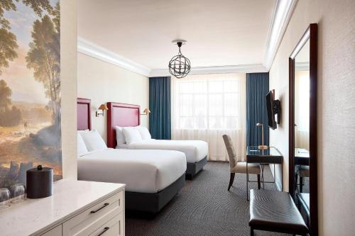 ハドソンにあるThe Wick, Hudson, a Tribute Portfolio Hotelのベッド2台とデスクが備わるホテルルームです。