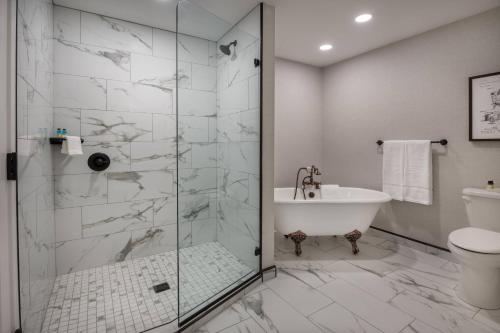 uma casa de banho com um chuveiro, uma banheira e um WC. em The Wick, Hudson, a Tribute Portfolio Hotel em Hudson
