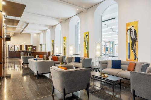 hol z kanapami i krzesłami w budynku w obiekcie Sheraton Hannover Pelikan Hotel w Hanowerze